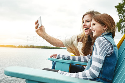 Buy stock photo Shot of a mother and her daughter taking a selfie together outdoors