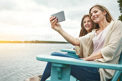 Buy stock photo Shot of a mother and her daughter taking a selfie together outdoors