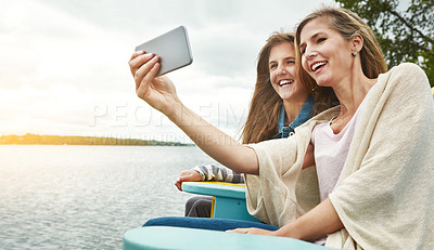 Buy stock photo Shot of a mother and her daughter taking a selfie together outdoors