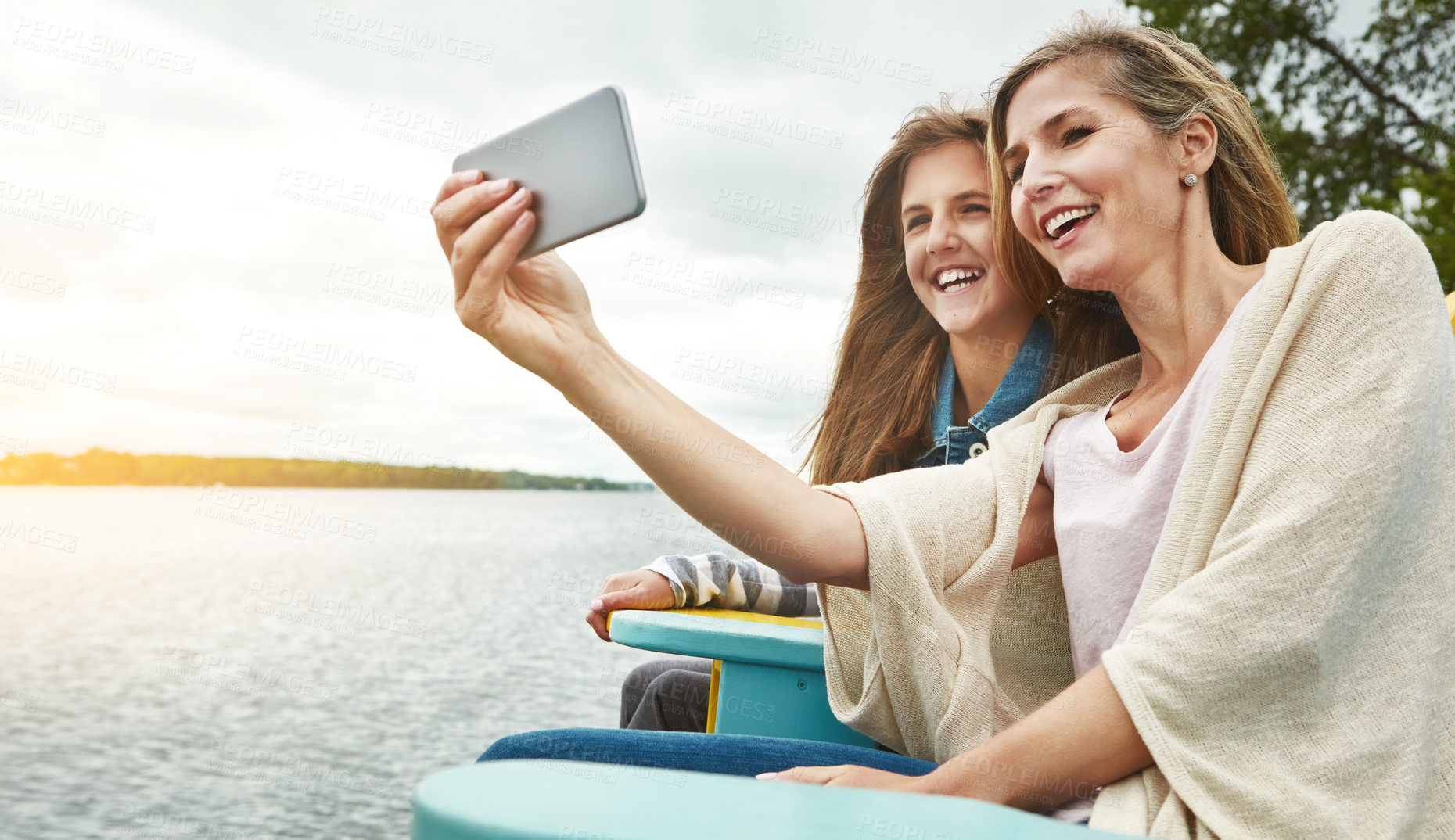 Buy stock photo Shot of a mother and her daughter taking a selfie together outdoors