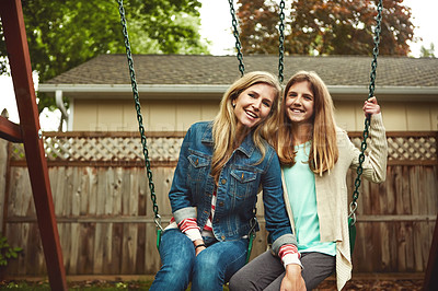 Buy stock photo Shot of a mother and her daughter playing on a swing in their backyard