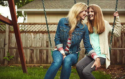 Buy stock photo Shot of a mother and her daughter playing on a swing in their backyard