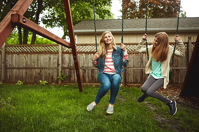 Buy stock photo Shot of a mother and her daughter playing on a swing in their backyard