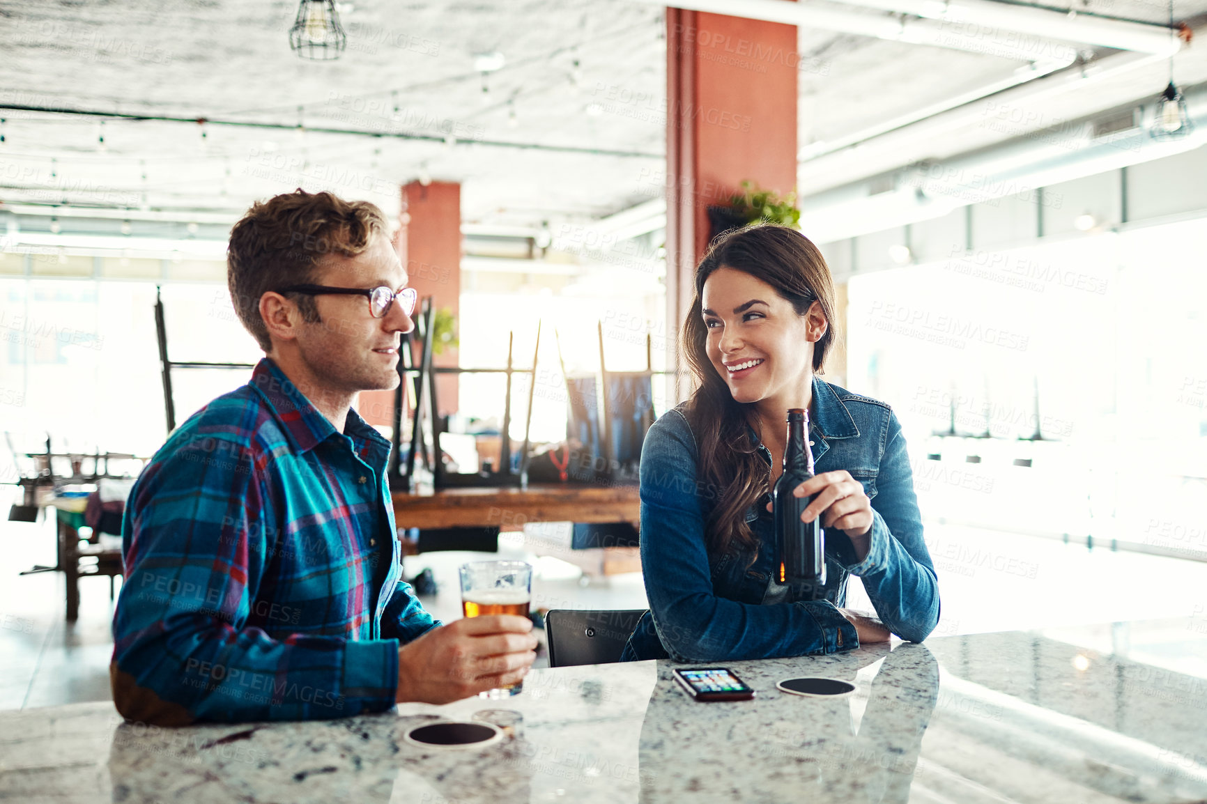 Buy stock photo Shot of a couple enjoying a drink at a bar