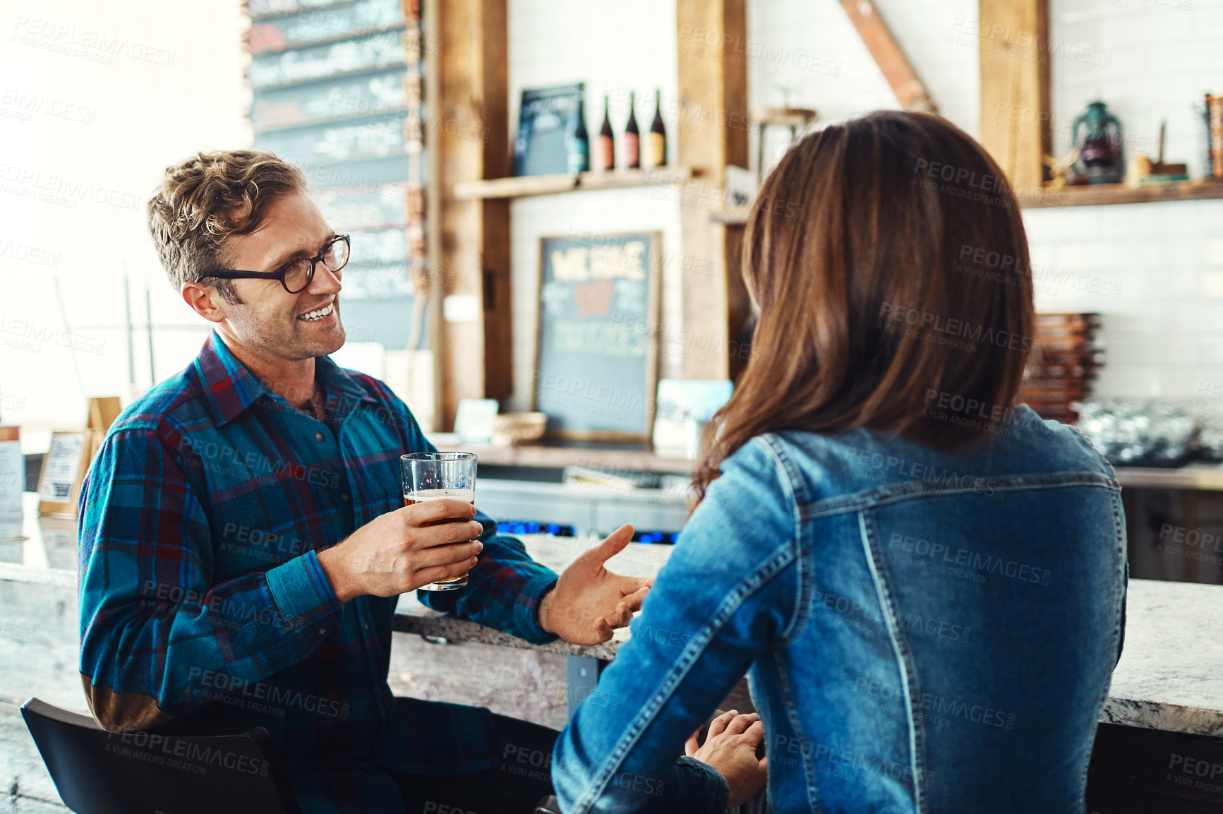 Buy stock photo Shot of a couple enjoying a drink at a bar