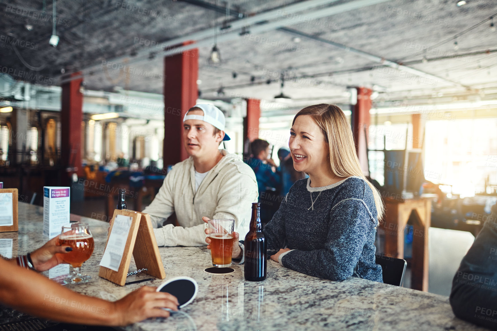 Buy stock photo Shot of a young couple enjoying a drink at a bar