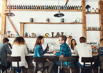 Buy stock photo Shot of a young couple enjoying a drink at a bar