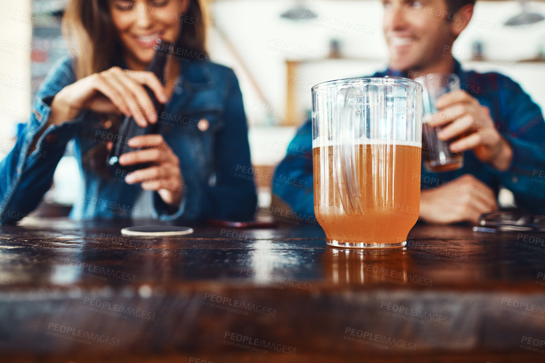 Buy stock photo Beer, jug and smile with couple at bar for bonding, restaurant diner and valentines day event. Conversation, alcohol drink and pint with man and woman at pub for relationship, date and love together