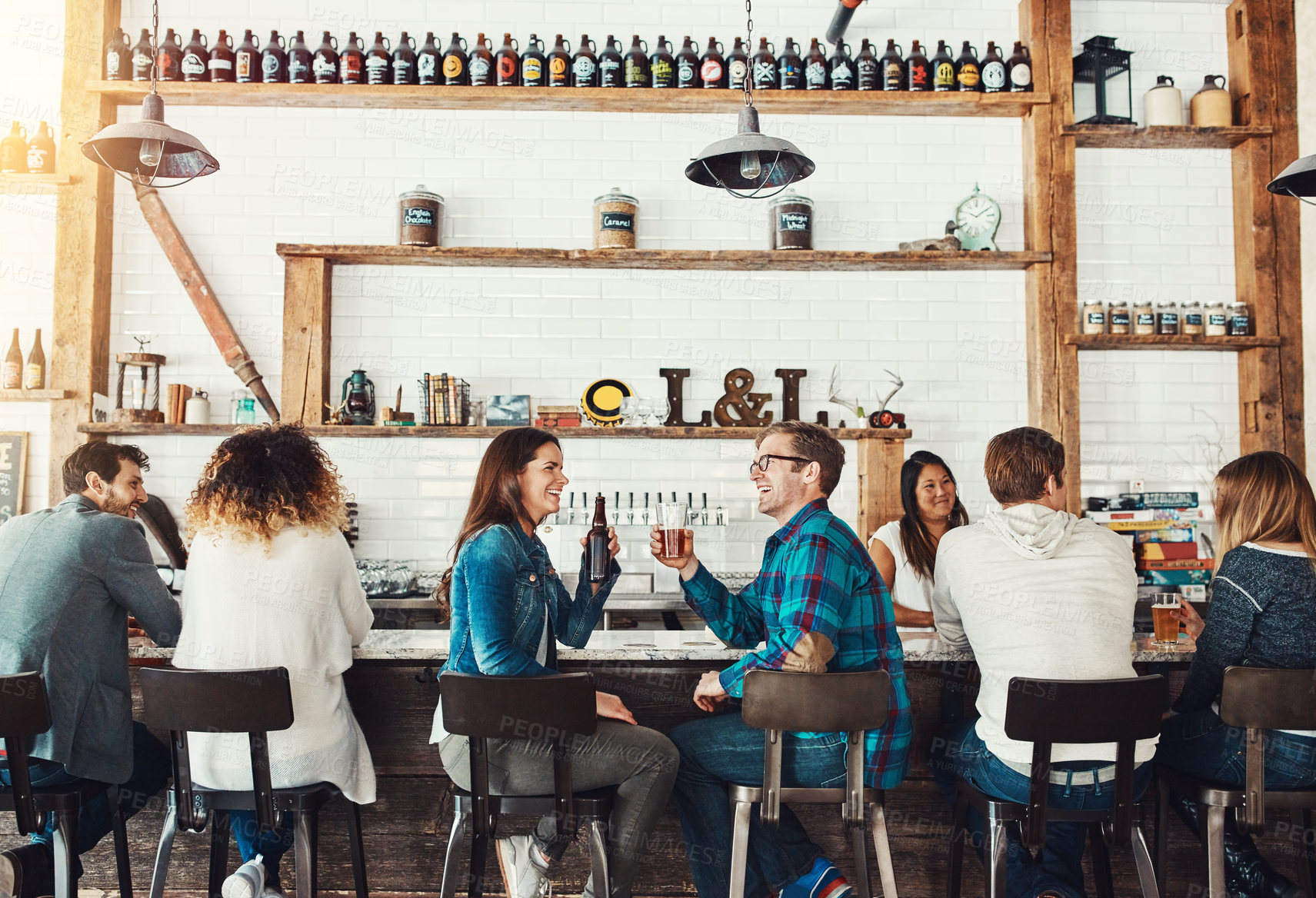 Buy stock photo Shot of young people enjoying a drink at a bar