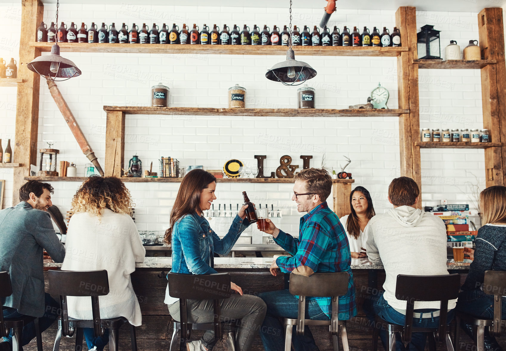 Buy stock photo Shot of young people enjoying a drink at a bar