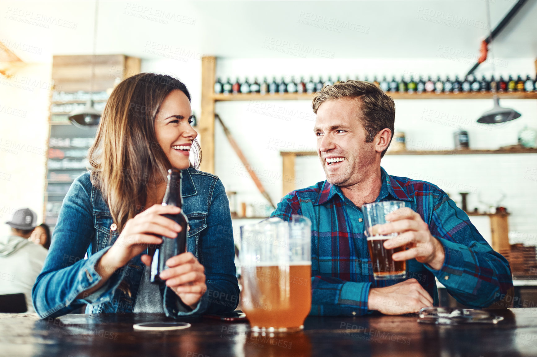 Buy stock photo Shot of a young couple enjoying a drink at a bar