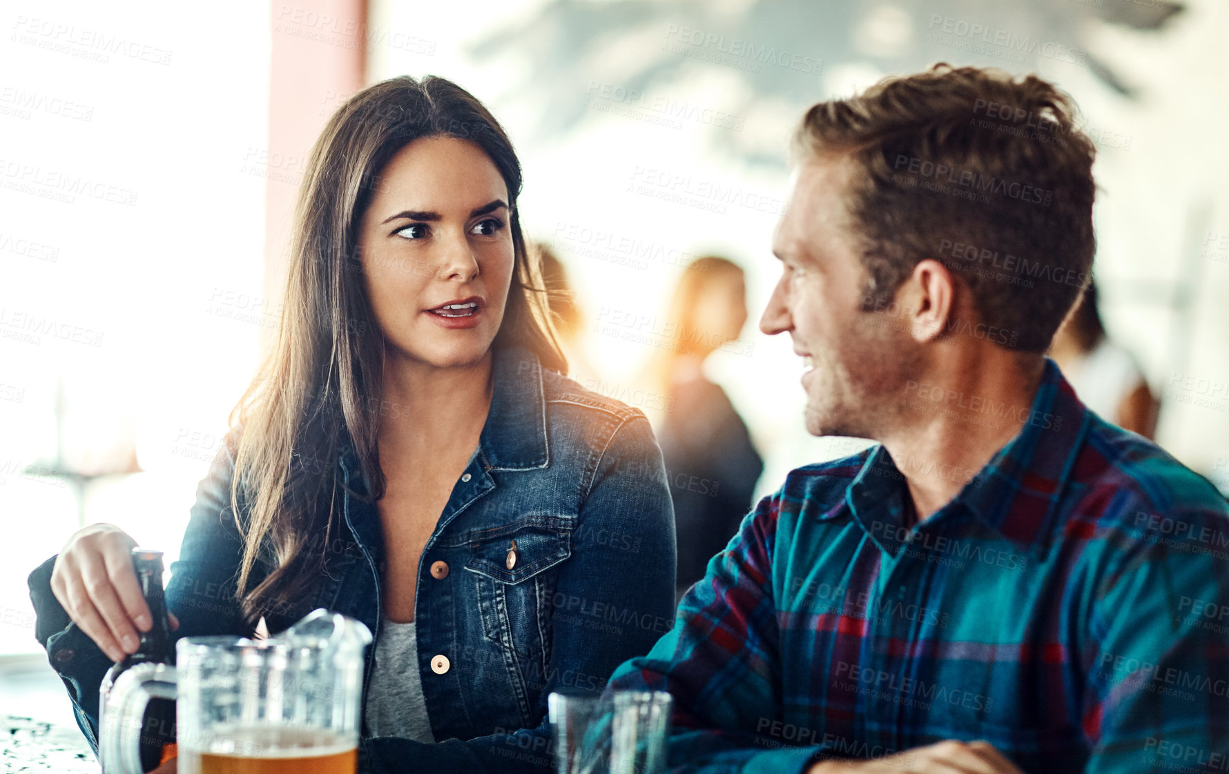 Buy stock photo Shot of a young couple enjoying a drink at a bar