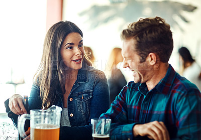 Buy stock photo Shot of a young couple enjoying a drink at a bar