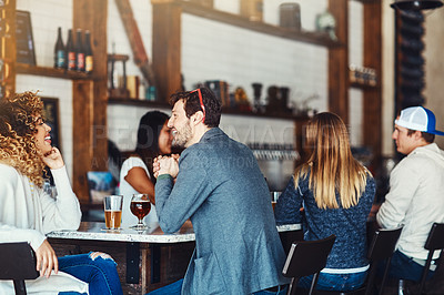 Buy stock photo Shot of a young couple enjoying a drink at a bar