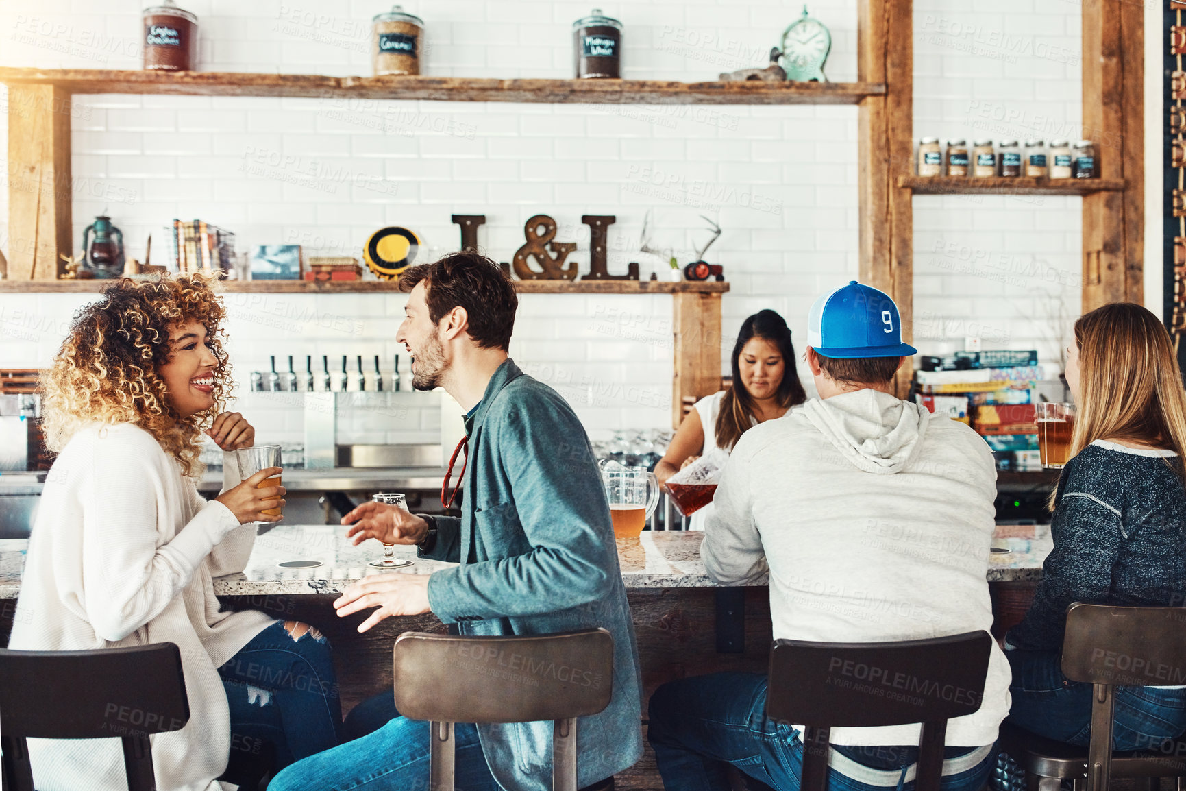 Buy stock photo Shot of a young couple enjoying a drink at a bar