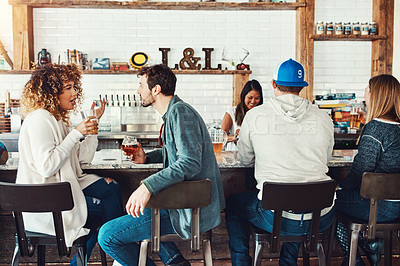 Buy stock photo Shot of young people enjoying a drink at a bar