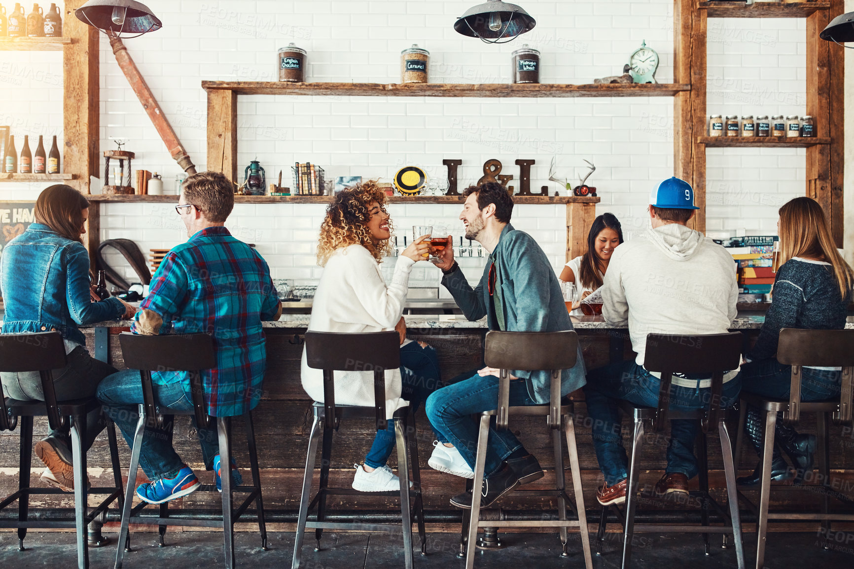 Buy stock photo Shot of young people enjoying a drink at a bar