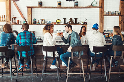 Buy stock photo Shot of young people enjoying a drink at a bar