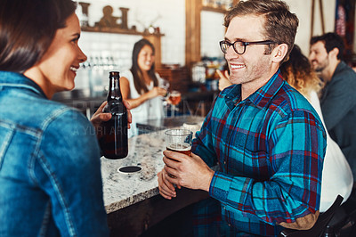 Buy stock photo Shot of a young couple enjoying a drink at a bar