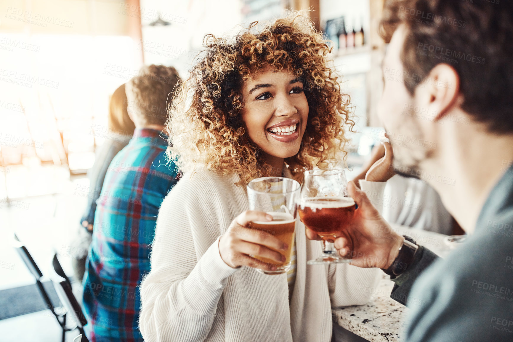 Buy stock photo Shot of a young couple enjoying a drink at a bar