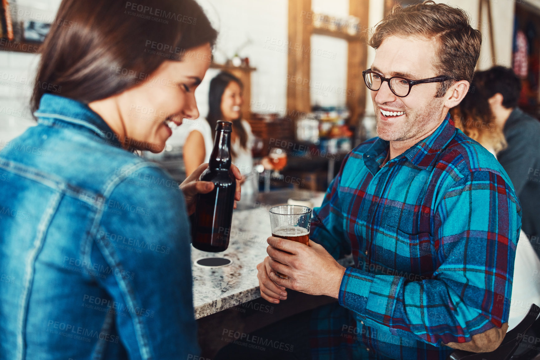 Buy stock photo Shot of a young couple enjoying a drink at a bar