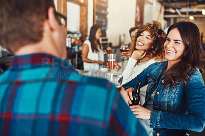 Buy stock photo Shot of a young couple enjoying a drink at a bar