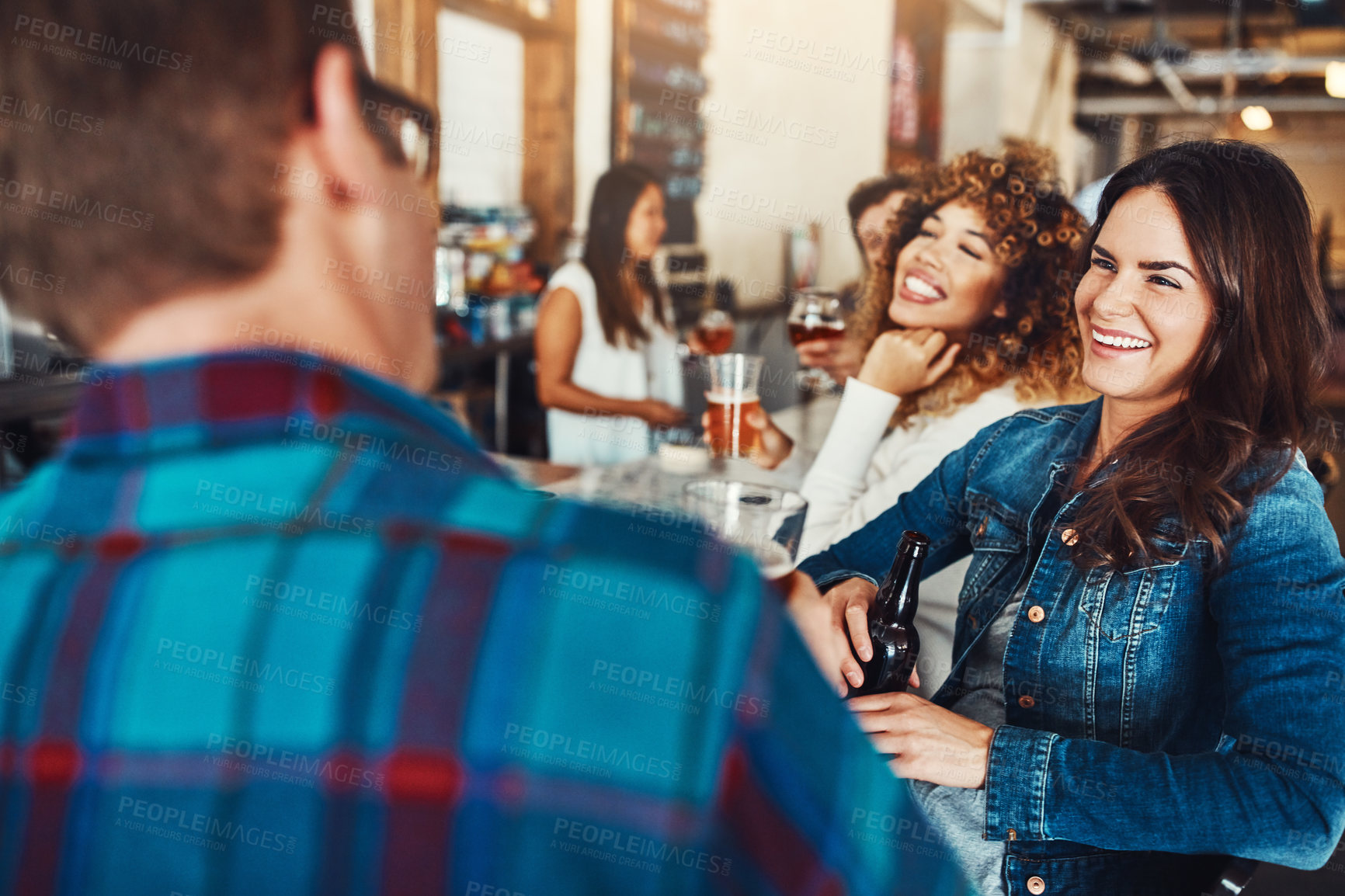 Buy stock photo Shot of a young couple enjoying a drink at a bar