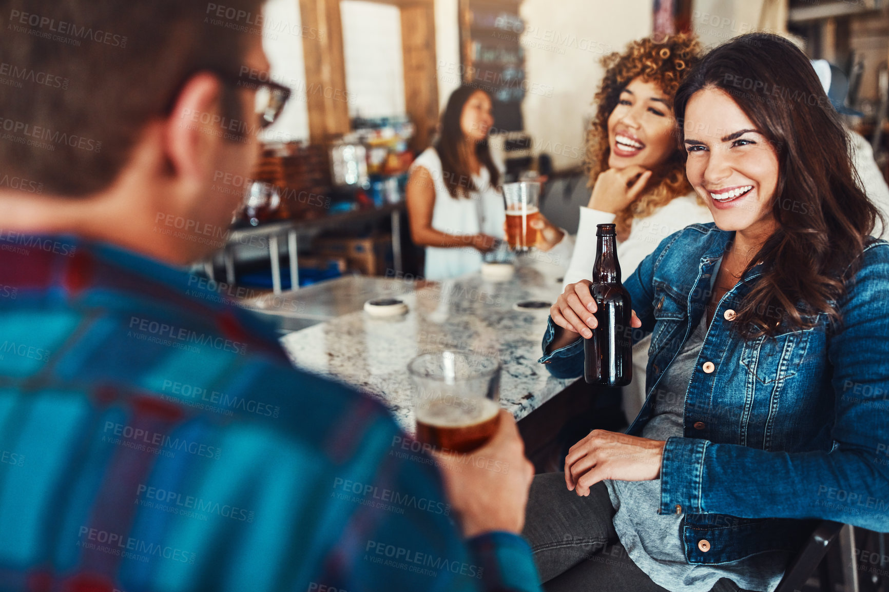 Buy stock photo Shot of a young couple enjoying a drink at a bar