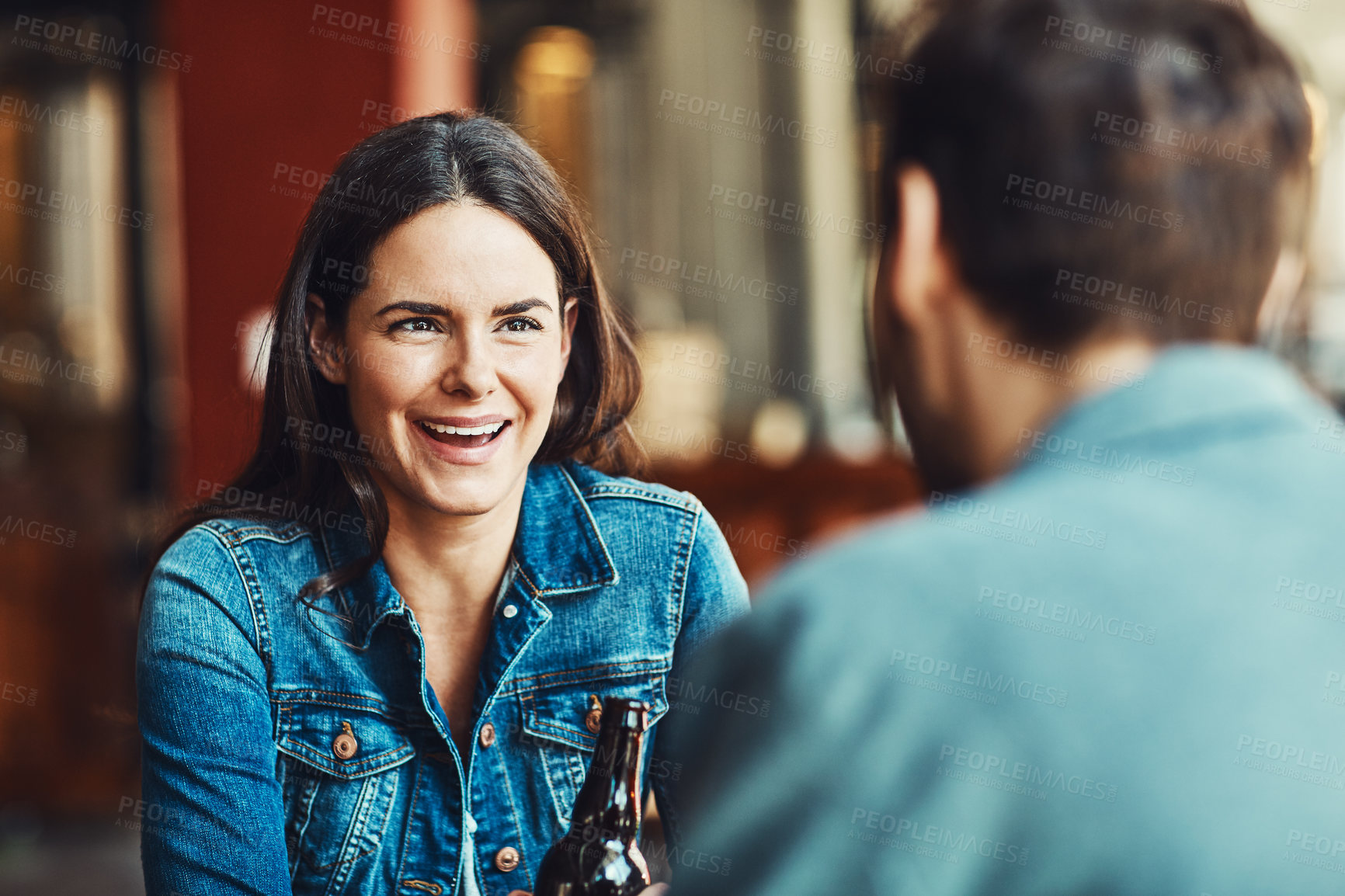 Buy stock photo Shot of a happy young woman enjoying the company in a bar