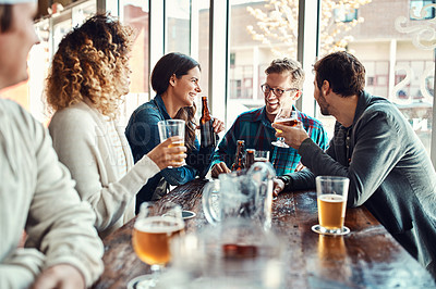 Buy stock photo Shot of a group of friends enjoying themselves at a bar