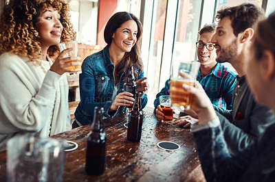 Buy stock photo Shot of a group of friends enjoying themselves at a bar