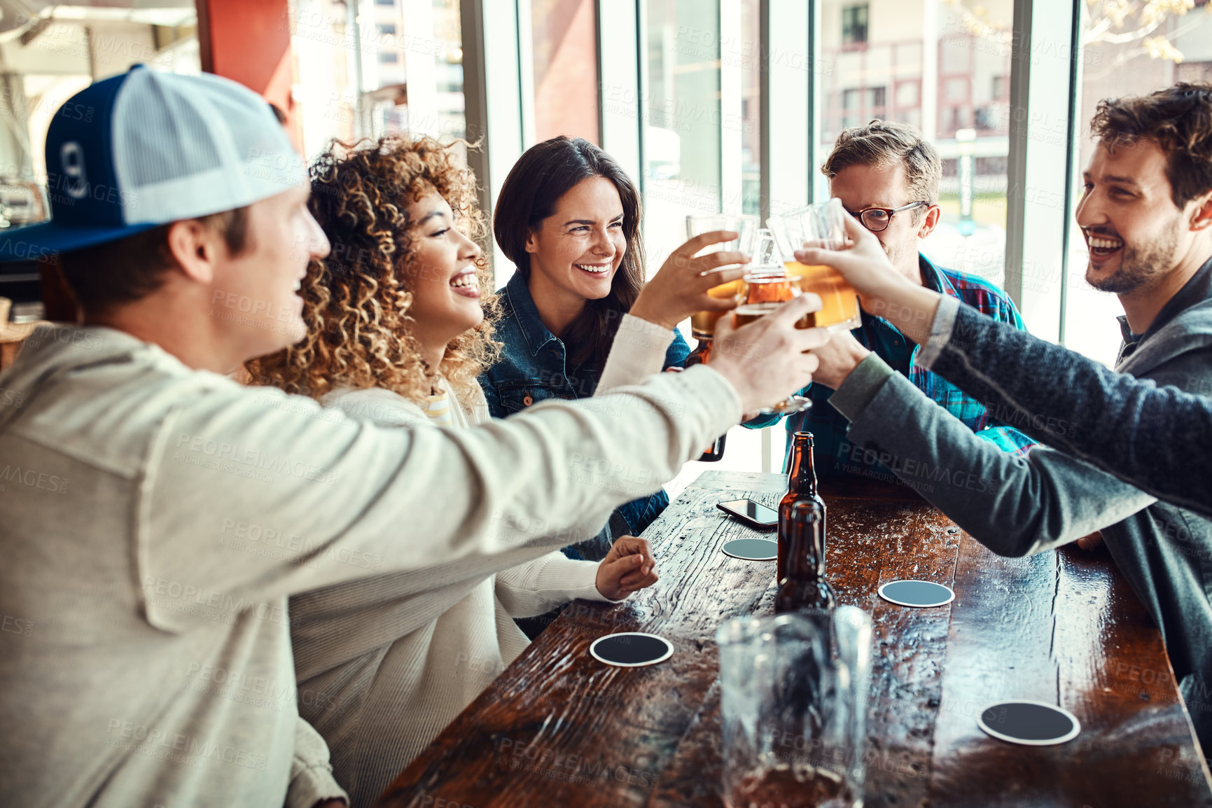 Buy stock photo Toast, beer and friends at hangout in celebration of birthday event in urban New York bar. Group of people with smile for happiness and gathering together with alcohol beverage at summer lunch