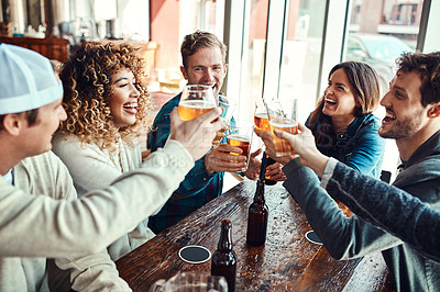 Buy stock photo Shot of a group of friends making a toast while enjoying themselves in a bar