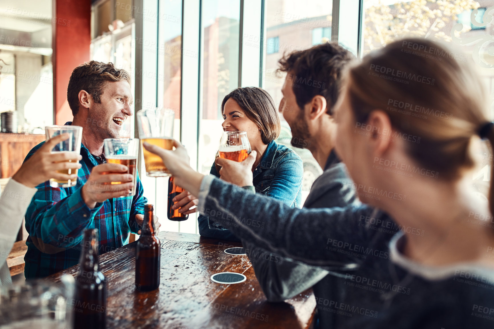 Buy stock photo Friends, people and laughing with beer for cheers in pub on date for reunion, gathering and fun. Glass, smile and happy for celebration with bonding, drinking alcohol and together in bar for support