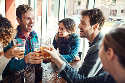 Buy stock photo Shot of a group of friends making a toast while enjoying themselves in a bar