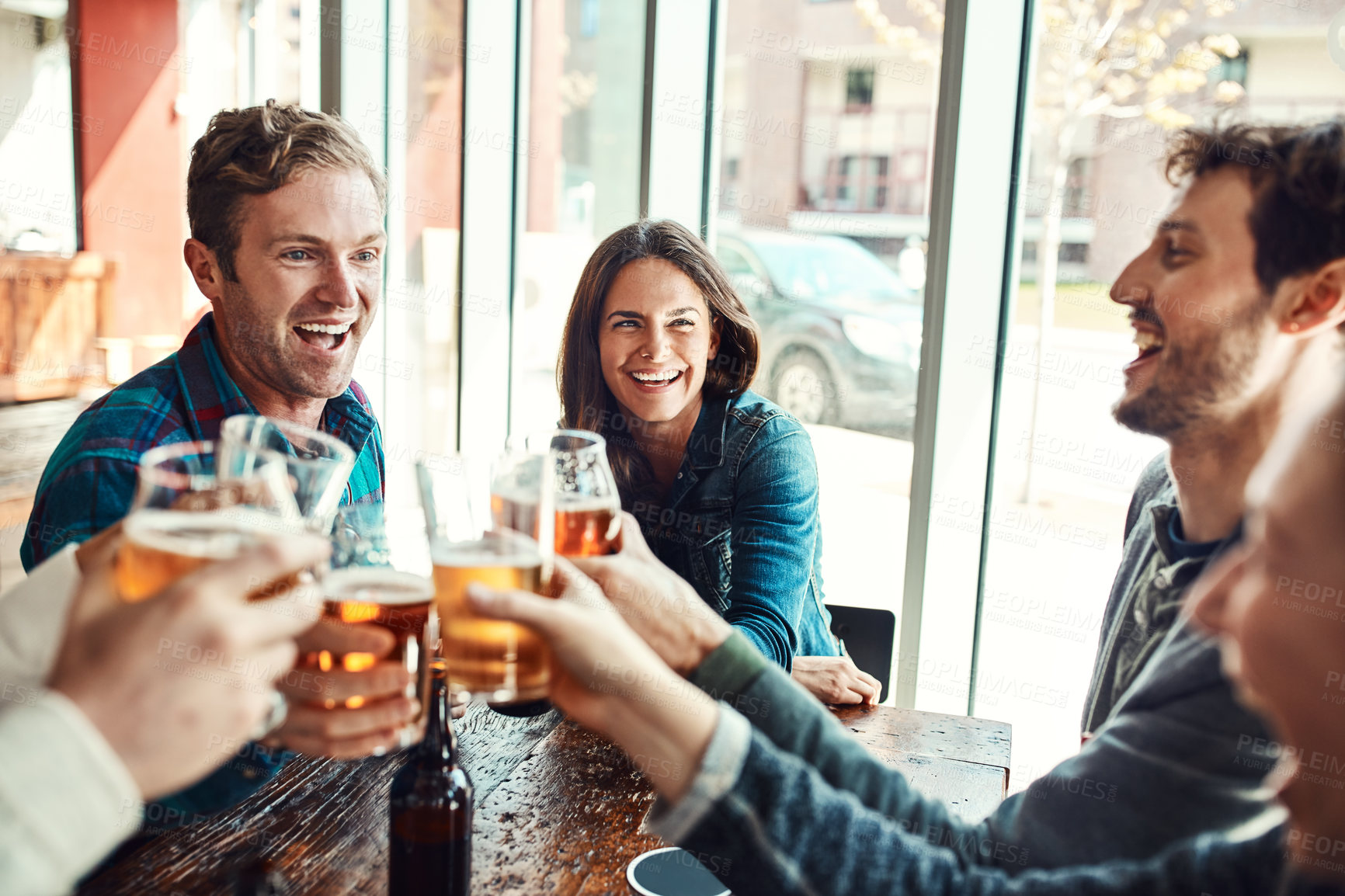 Buy stock photo Shot of a group of friends making a toast while enjoying themselves in a bar