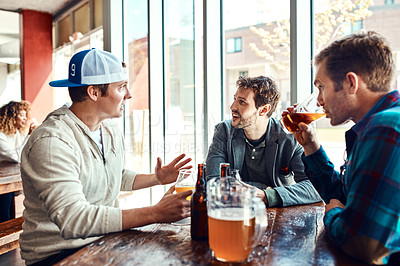 Buy stock photo Shot of three male friends having drinks in a bar