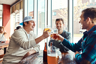 Buy stock photo Shot of three male friends having drinks in a bar