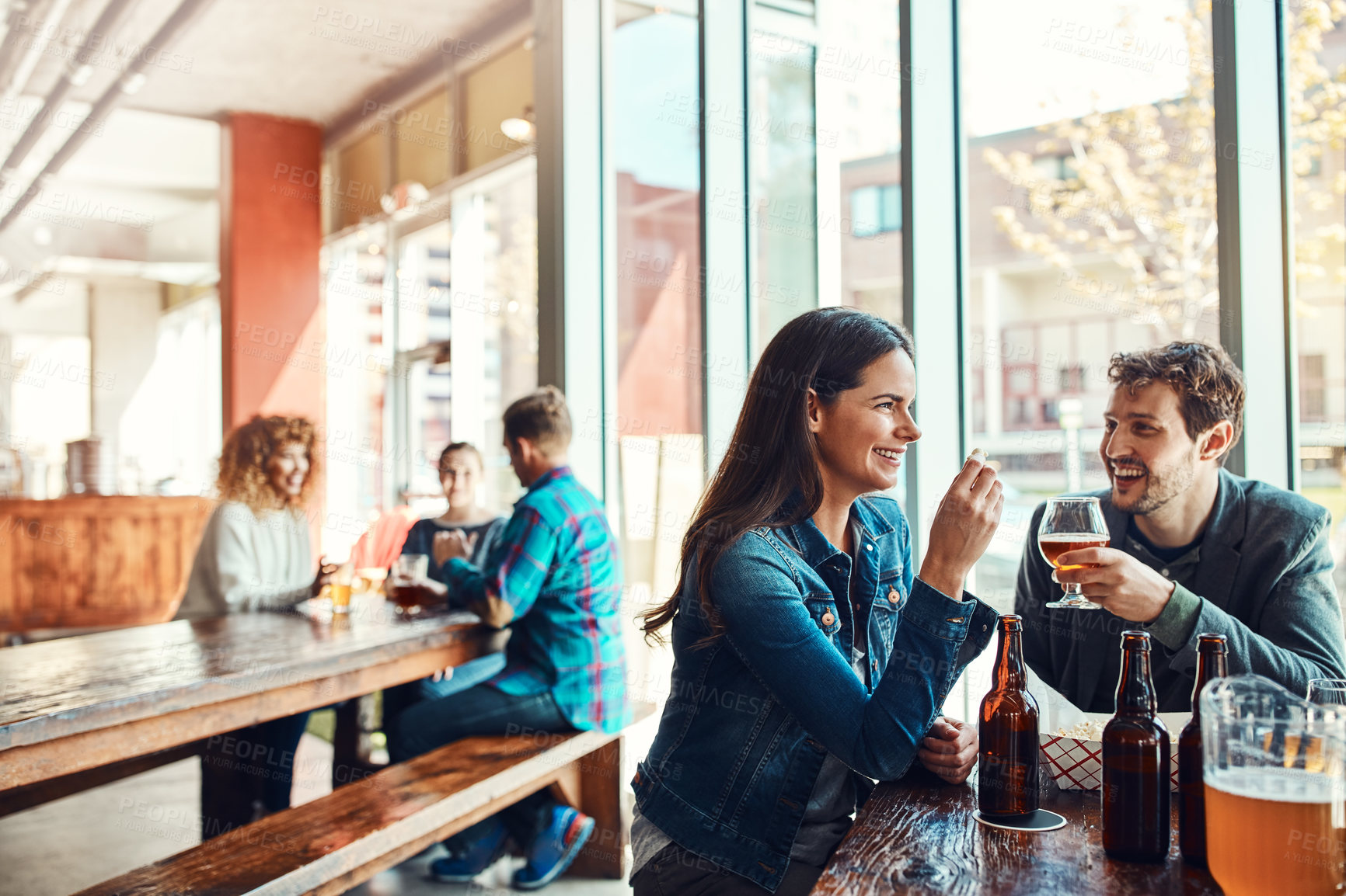 Buy stock photo Relax, couple and laughing with drinks at pub for funny conversation, bonding together or date. Healthy relationship, people and chat with alcohol at bar for happy hour, joke or connection on weekend