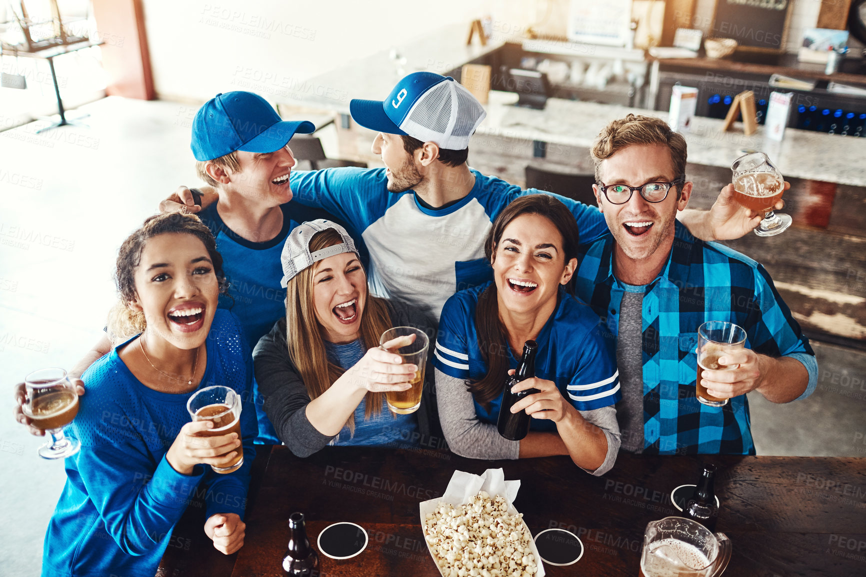 Buy stock photo Alcohol, sports and fans in pub for victory game with goal for celebration in support together. Excited, people and group of friends drink beer and watch broadcast television of team match in bar.