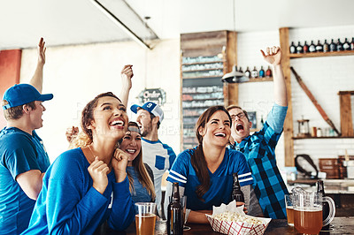 Buy stock photo Shot of a group of friends cheering while watching a sports game at a bar