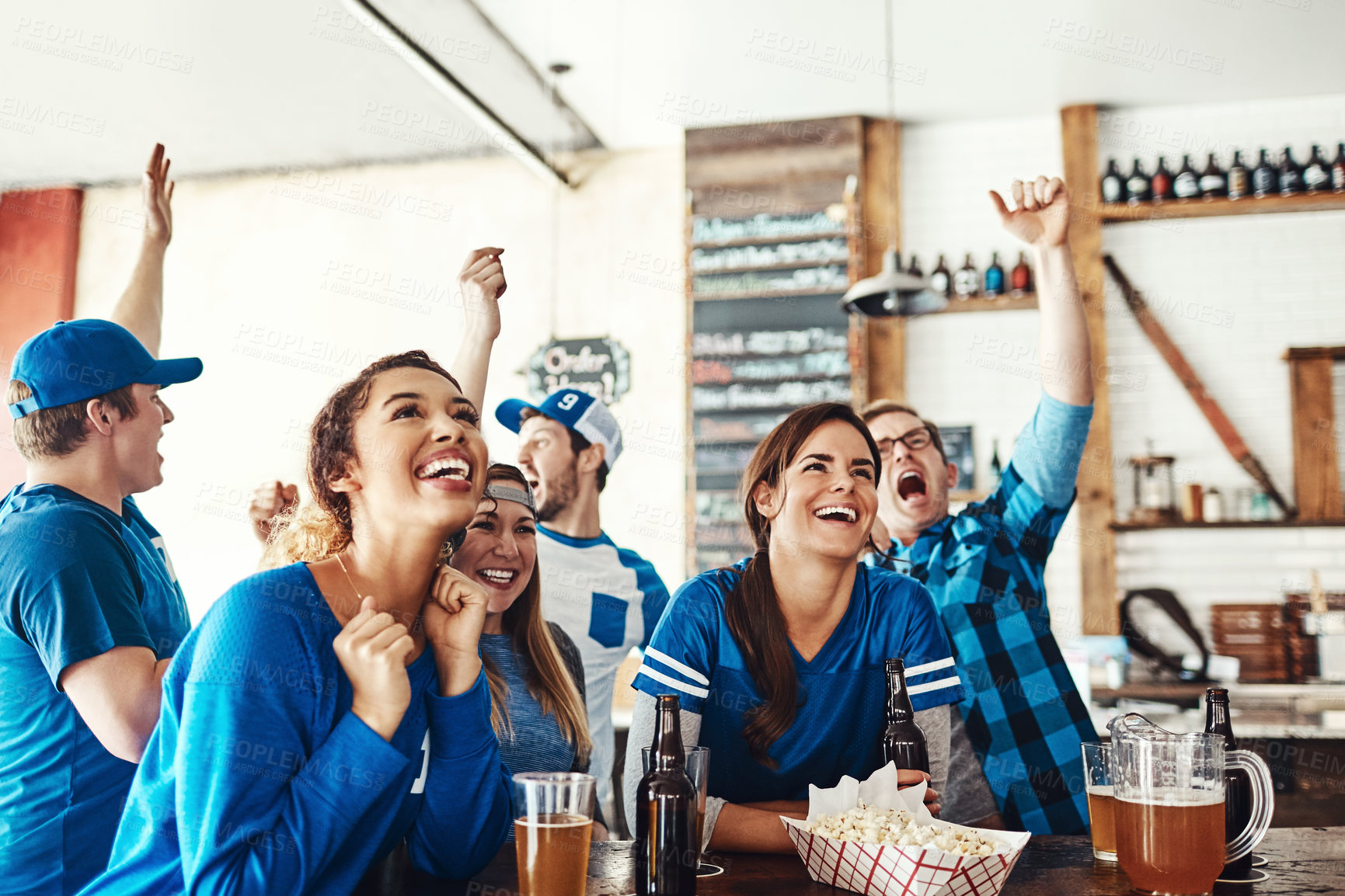 Buy stock photo Friends, cheer and watching tv at sport pub with game, goal and beer at restaurant with celebration. Fan group, smile and happy with esports, live broadcast and match together at bar with win