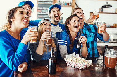 Buy stock photo Shot of a group of friends having beers while watching a sports game at a bar