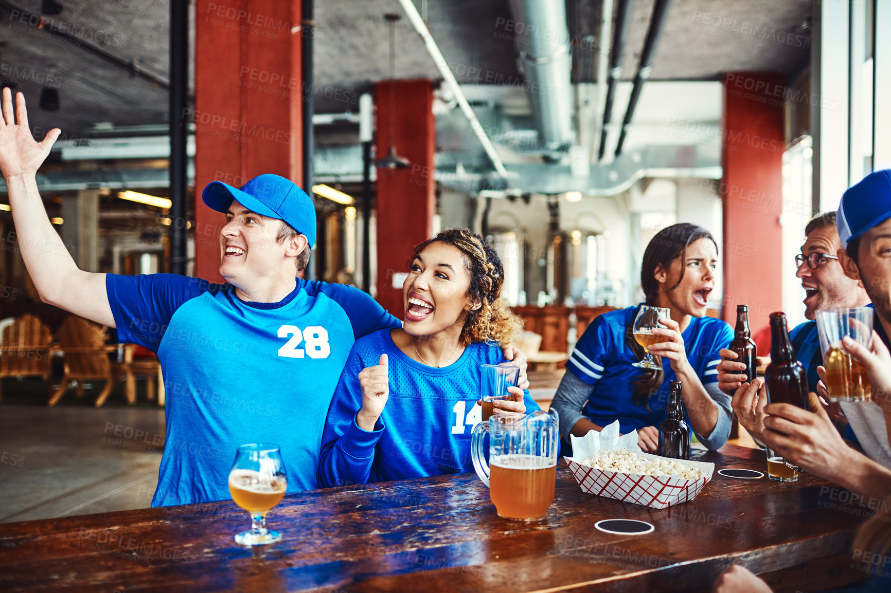 Buy stock photo Shot of a group of friends watching their favorite team live in a sports bar