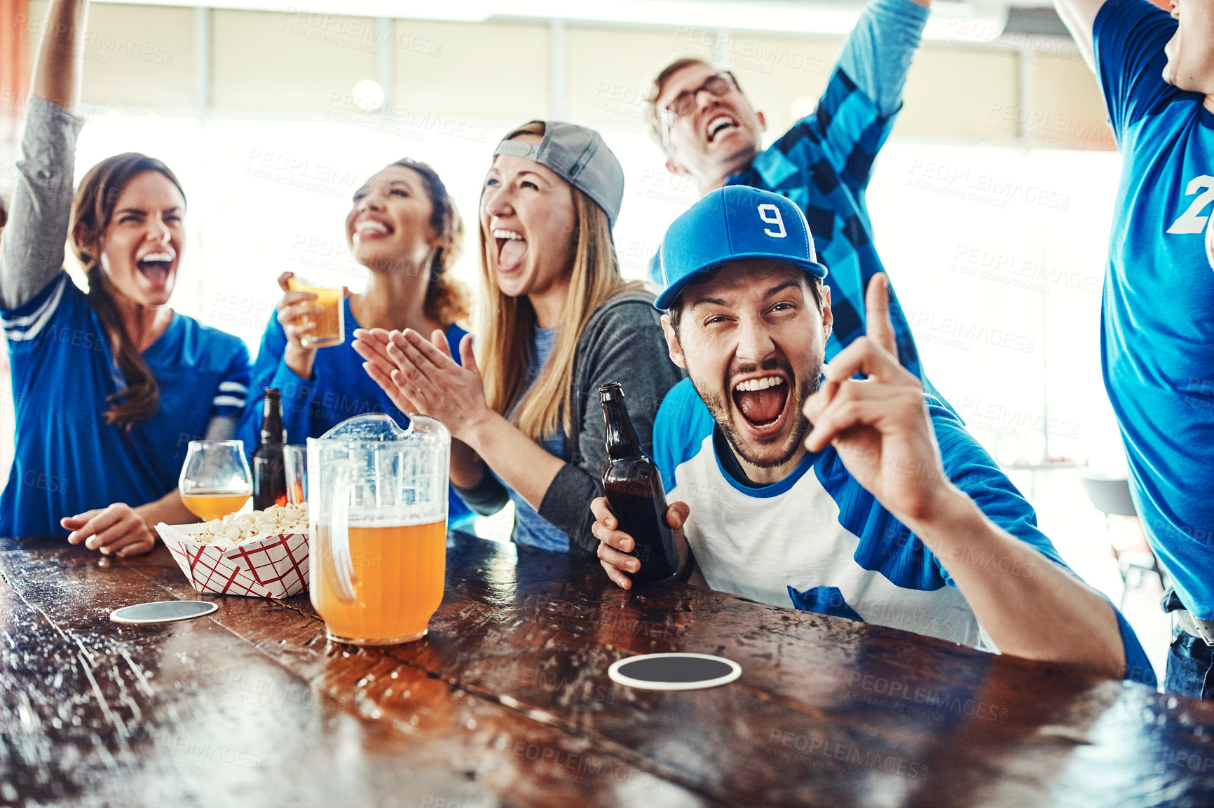 Buy stock photo Shot of people watching their favorite team live in a sports bar