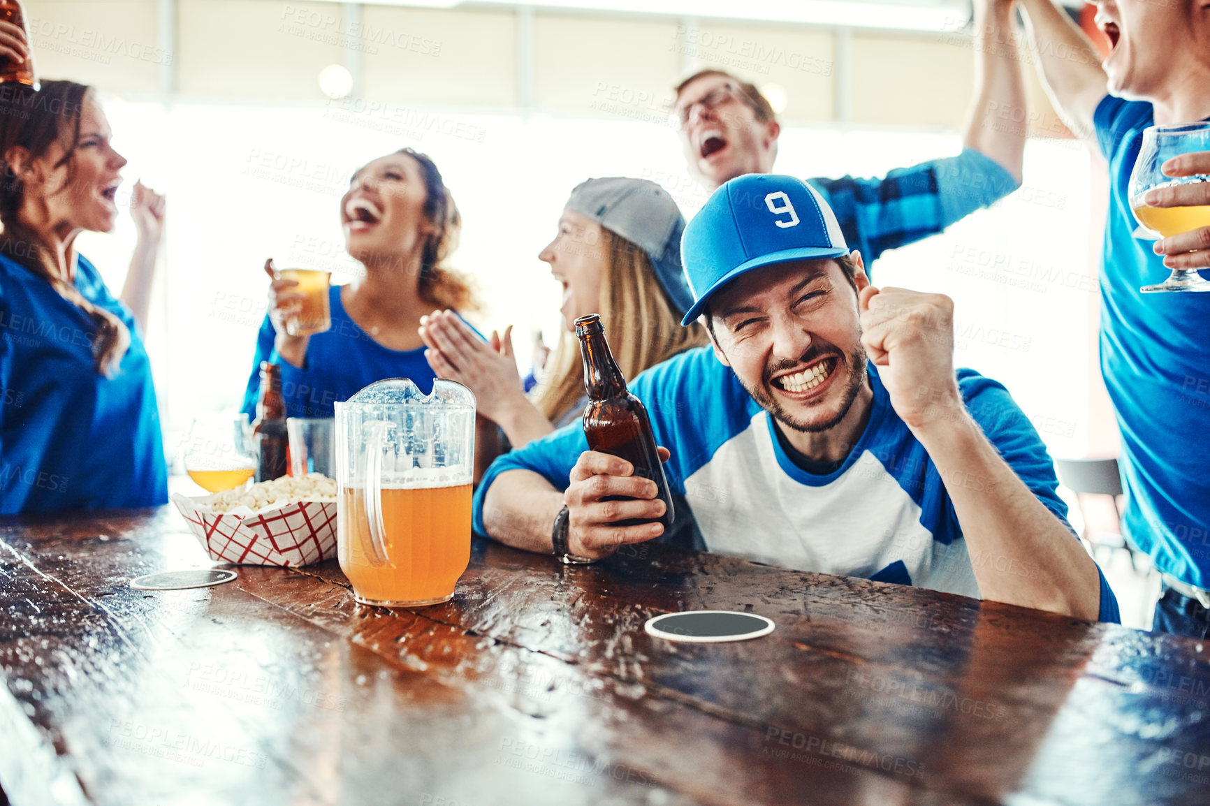 Buy stock photo Shot of people watching their favorite team live in a sports bar