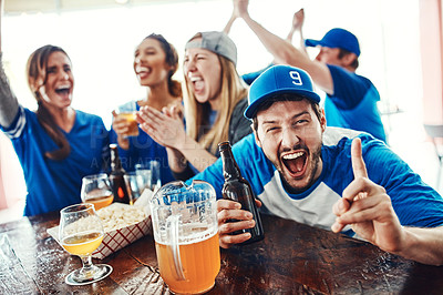 Buy stock photo Shot of people watching their favorite team live in a sports bar