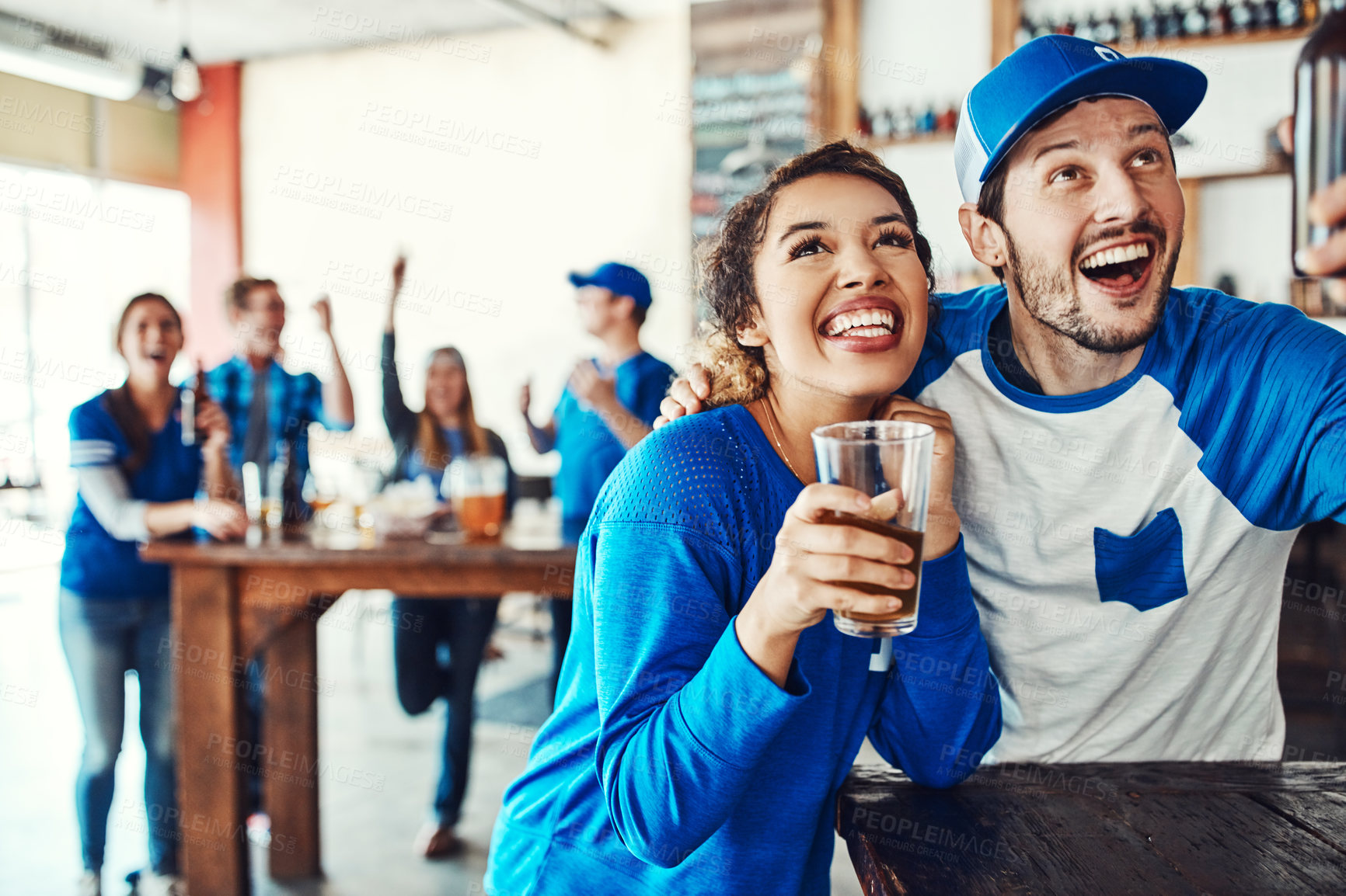 Buy stock photo Sports, pub and couple hug with beer to celebrate for winning match, fan support and game. Happy, dating and excited man and woman with alcohol, drinks and cheer for team victory, broadcast and score