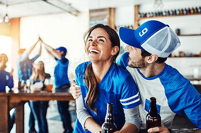 Buy stock photo Shot of a young couple having beer while watching the game in a bar