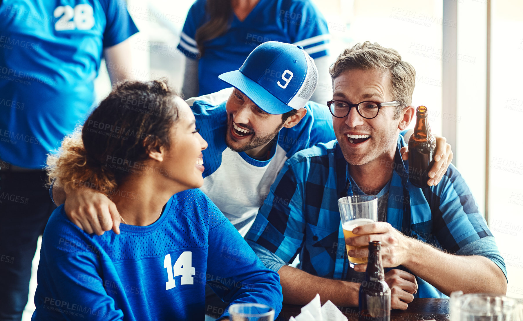 Buy stock photo A group of excited friends cheering on their favourite team at the bar